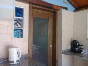 eine Glastür in einer Küche mit einer Kaffeemaschine in der Unterkunft Agua Azul poolside rest a luxurious rural woodland idyll in Cabeçadas + 56 Fotos