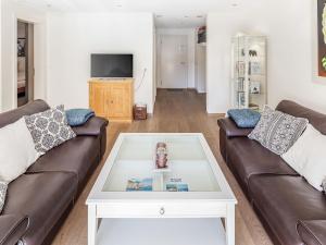 a living room with two couches and a coffee table at Apartment Chalet Smaragd-1 by Interhome in Grindelwald