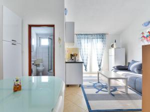 un soggiorno bianco con tavolo e letto di Apartment Jadran - NIN121 by Interhome a Nin