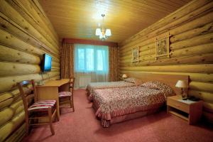 sypialnia z 2 łóżkami, biurkiem i telewizorem w obiekcie Hotel Semigorie w mieście Shaldovo