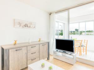 a living room with a tv and a large window at Apartment La Méditerranée by Interhome in Narbonne-Plage