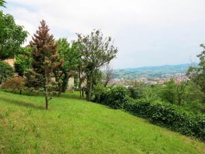 una collina erbosa con alberi e una città in lontananza di Holiday Home Villa Margherita - NZZ180 by Interhome a Nizza Monferrato