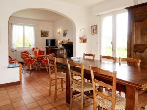 a kitchen and dining room with a wooden table and chairs at Holiday Home Les Genêts by Interhome in Plomeur
