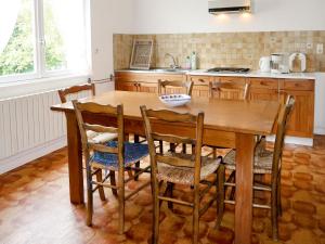 a kitchen with a wooden table and chairs at Holiday Home Les Genêts by Interhome in Plomeur