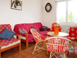 a living room with a couch and a table and chairs at Holiday Home Les Genêts by Interhome in Plomeur +14 photos