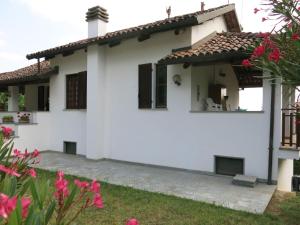 una casa bianca con patio e fiori di Holiday Home Villa Margherita - NZZ180 by Interhome a Nizza Monferrato
