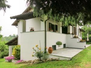 una casa bianca con fiori in cortile di Holiday Home Villa Margherita - NZZ180 by Interhome a Nizza Monferrato