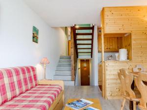 a living room with a couch and a staircase at Apartment Brelin La Challe 635 by Interhome in Les Menuires