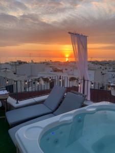a hot tub on a balcony with the sunset at New Dimora Valmar in Polignano a Mare