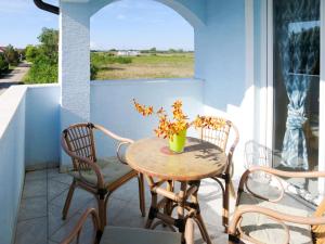 una mesa y sillas en un balcón con ventana en Apartment Jadran - NIN120 by Interhome, en Nin