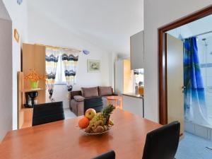 un bol de fruta en una mesa de madera en la sala de estar en Apartment Jadran - NIN120 by Interhome, en Nin