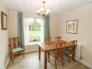 a dining room with a table and chairs and a window at Rhug Villa in Nefyn