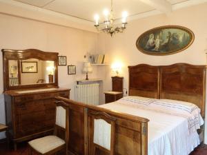 ドンゴにあるApartment Il Giardino by Interhomeの大きなベッド付きのベッドルーム1室、壁に絵画が飾られています。