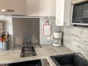 a kitchen with a sink and a stove top oven at Apartment Les Agathes Plus by Interhome in Cap d'Agde