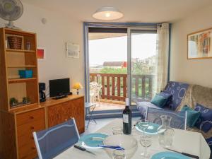 un salon avec une table avec une bouteille de vin dans l'établissement Apartment Gruissan Plage by Interhome, à Gruissan