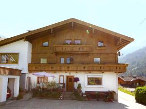 a large wooden house with a balcony on top at Apartment Ratgebgut by Interhome in Zell am See