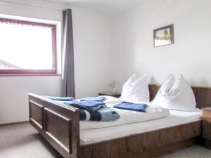 Un dormitorio con una cama con sábanas blancas y una ventana. en Apartment Haus Zimmermann by Interhome, en Innsbruck