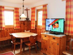 een eetkamer met een tv en een houten tafel bij Holiday Home Wierer-1 by Interhome in Schlitters