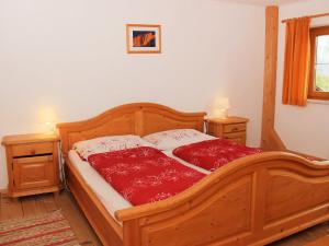 een slaapkamer met een houten bed met 2 nachtkastjes bij Holiday Home Wierer-1 by Interhome in Schlitters