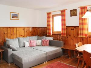 een bank in een kamer met houten lambrisering bij Holiday Home Wierer-1 by Interhome in Schlitters