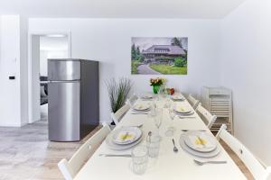 a white dining room with a white table with plates and dishes at Wohnung 14 - ohne Auto in den Europa-Park in Ringsheim