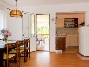 una cucina e una sala da pranzo con tavolo e sedie di Apartment Dorka - RAB303 by Interhome a Rab