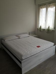 - un lit blanc dans une chambre avec 2 fenêtres dans l'établissement Lilla, à Bellagio