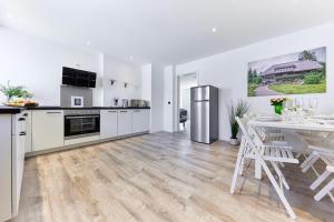 a kitchen with white cabinets and a table with chairs at Wohnung 14 - ohne Auto in den Europa-Park in Ringsheim +10 photos