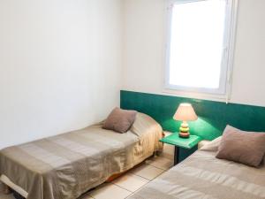 um quarto com duas camas e um candeeiro sobre uma mesa em Apartment Thalacap by Interhome em Banyuls-sur-Mer