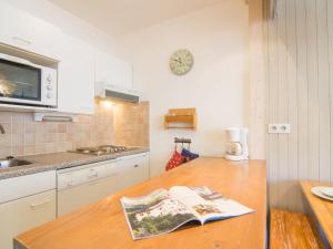 een keuken met een houten aanrechtblad waarop een boek ligt bij Apartment Le Curling B - Val Claret-27 by Interhome in Tignes +14 foto's