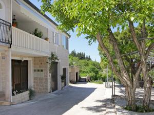 a building with a tree next to a street at Holiday Home Edo - BRC601 by Interhome in Nerežišće