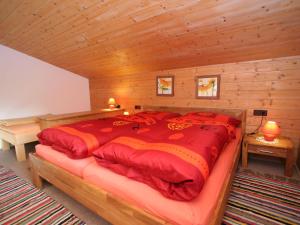 una camera da letto con un grande letto rosso in una cabina di Apartment Annelies-3 by Interhome a Mühlfeld