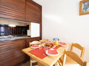 a wooden table with plates of food on it in a kitchen at Apartment Le Borsat - Val Claret-10 by Interhome in Tignes