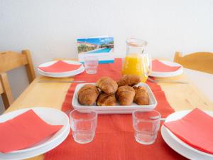 a table with a plate of donuts and orange juice at Apartment Le Borsat - Val Claret-10 by Interhome in Tignes