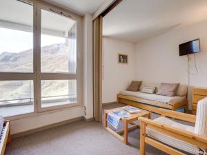 un salon avec un canapé et une fenêtre dans l'établissement Apartment Origanes 324 by Interhome, aux Menuires