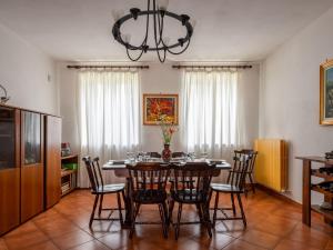 a dining room with a table with chairs and a chandelier at Holiday Home Casa Nocciola by Interhome in Ferrere +23 photos