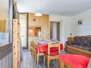 a dining room with a table and a couch at Apartment Pelvoux-1 by Interhome in Les Menuires