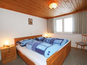 een slaapkamer met een bed met twee blauwe kussens erop bij Apartment Mangeng-2 by Interhome in Bartholomäberg