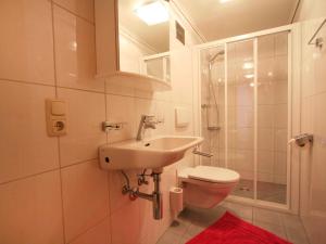 een badkamer met een wastafel, een toilet en een douche bij Apartment Mangeng-2 by Interhome in Bartholomäberg