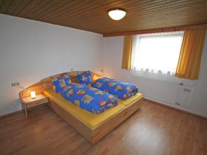 バルトロメベルクにあるApartment Mangeng-1 by Interhomeのベッドルーム1室(青い枕のベッド1台、窓付)