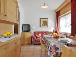 a kitchen and living room with a table and a couch at Apartment Cincelli - Latemar by Interhome in Pozza di Fassa +24 photos