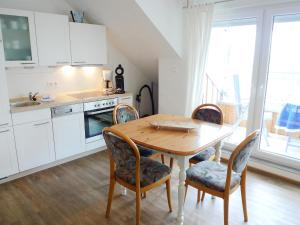 a kitchen with a wooden table and chairs in a kitchen at Apartment Dehne-2 by Interhome in Norddeich