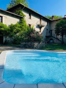 a large blue swimming pool in front of a house at Mulino Gorretta Langhe House with swimming pool in Torre Bormida