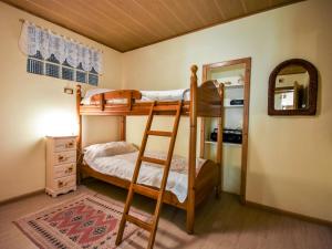 ein Schlafzimmer mit Etagenbetten mit einer Leiter und einem Spiegel in der Unterkunft Apartment Garibaldi by Interhome in Predazzo