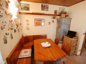 Zimmer mit einem Holztisch und einem Kamin in der Unterkunft Apartment Garibaldi by Interhome in Predazzo