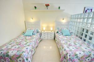 a bedroom with two beds and a dresser at Studio in beachfront complex in El Duque area, Costa Adeje in Adeje +16 photos