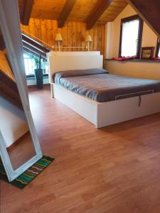 ein Schlafzimmer mit einem Bett in einem Zimmer mit Holzböden in der Unterkunft Maison Bellevue - locazione turistica breve in Aosta