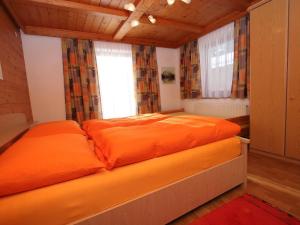 een oranje bed in een kamer met een raam bij Apartment Annelies-2 by Interhome in Mühlfeld +20 foto's