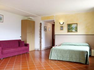 トレモージネ・スル・ガルダにあるApartment La Tartufaia-8 by Interhomeのベッドルーム(ベッド1台、紫色のソファ付)