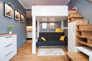 una pequeña sala de estar con sofá y escalera en Apartamenty Zulu, en Cracovia